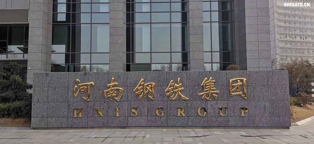 6月1日，河南鋼鐵集團周口基地簡稱（周鋼）二期寬厚板項目控制中心迎來重要里程碑：當操作員按下5500mm精軋機的軋制按鈕，通紅的鋼板如熔金般奔騰穿過軋輥，標志著5500mm軋機熱試圓滿成功。這一震撼場景與5月31日RH真空精煉爐、熱處理線熱試成功交相輝映，正式宣告世界首條“5600mm+5500mm雙超寬機架”寬厚板生產線全線貫通！生產線總長度達到1.4公里，構成了國內已知更長的寬厚板軋鋼車間，連接了近20個精密工序，深基坑群實現了全線的貫通布局。至此，河南鋼鐵集團強勢躋身全球鋼鐵制造“一梯隊”，其智能化、綠色化發展及特鋼轉型進程由此開啟全新篇章！